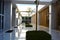 The interior of a bright, sunny, symmetrical corridor-type lobby with lattice panels, windows, rhythmic columns, greenery, bushes