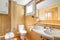 Interior of bright yellow bathroom with shower, bathtub, toilet and sink