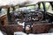 The interior of burnt-out car. Melted plastic of dashboard and rusted remains of seats. Selective focus