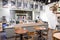 Interior of cafe showing laid wooden tables with cutlery in shabby chic rustic styled eating area with counter and serving area be