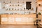 Interior of cafeteria with wooden bar counter, shelves and board with drawn coffee cup.