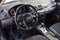 The interior of the car Mazda 3 with a view of the steering wheel, dashboard, seats and multimedia system with light gray trim and