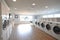 Interior clean white laundry room with front load washer and dryer units. Generative AI