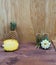 Interior composition of a home on wood table or floor and wall. Handmade white lotus aroma candle. Tropical fruit fresh pineapple