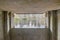 Interior of a concrete gazebo with a window observing the water flowing from the fountain into a lake