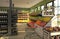 The interior of a convenience  shop with a shopping cart in the foreground. Commercial equipment in store with fruits, wine and