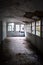 Interior corridor of an abandoned hospital with collapsing roof and broken windows