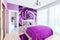 Interior of cozy bedroom in bright violet tones. Large mirrored