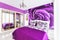 Interior of cozy bedroom in bright violet tones. Large mirrored