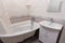 Interior of a cozy ordinary bathroom with a washbasin, a bathtub and a mirror