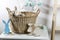 Interior decoration for Easter. rag rabbit peeks out of a wicker willow basket on the table. A garland of wooden painted eggs