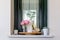 Interior decoration: home corner with a pink rose, a dried pumpkin, a glass vase with wild flowers