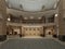 The interior design of the hotel lobby with a large multi-storey interior space. Stone columns, balconies and interfloor elevators