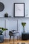 Interior design of scandinavian living room with black mock up poster map, grey stool and personal accessories.