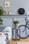 Interior design of scandinavian living room with grey sofa, mock up photo frames, plants, pillows, marble stool, bicycle.