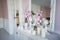 Interior design of white room with beautiful flowers on the served table. Big creative classical mirror at the