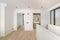 Interior of empty flat with doorways leading to bedroom and bathroom. White and clean room in refurbished apartment