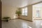 Interior of the empty living room in the cottage with tiled floors and large windows. Sunny interior