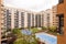 Interior facades of a block patio of residential buildings with gardens and summer pools with canvas