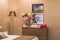 Interior of a female bedroom, beige walls, a wooden chest of drawers, flowers, decor, a gold floor lamp, a luxury mirror