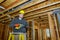 Interior frame of a new house under construction worker drills hole with wooden ceiling the electrical wiring