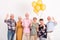 interior with group of senior happy friends holding bunch of balloons