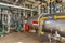 Interior of an industrial boiler room with boilers, many pipes, valves and sensors