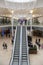 Interior inside of modern shopping centre mall with escalators and luxury chandelier