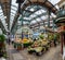 The interior of Leeds Market with market stalls selling fruit and veg