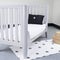 Interior of light baby room with a cozy crib and woven wicker boxes for clothes or accessories