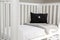 Interior of a light baby room with a soft pillow and blanket on a modern whitewashed cozy crib