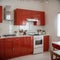 Interior of light kitchen with red fridge white counters and dining table