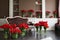 The interior of the living room in brown tones with large bouquets of red tulips in vases.