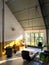 Interior of a loft. Living room with midcentury modern furniture. Concrete floor and plants. Mustard yellow chair