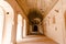 Interior of the long hallway with an archway entrance in Orchha Fort in India