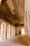 Interior of the long hallway with an archway entrance in Orchha Fort in India