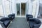 Interior of the medical clinic bright foyer with black chairs