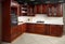 Interior of modern kitchen in classic style with golden elements cherry alder wood cabinetry with built-in appliances electric or