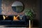 The interior of a modern living room with a dark blue sofa next to a brick wall on which a horizontal poster hangs, in the