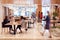 Interior Of Modern Open Plan Office With People Working And Commuters Arriving On Bikes