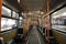 Interior of the modern trolleybus, blue seats, orange handrails, windows