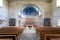 interior of the old abandoned church with stone walls, view from behind the pews to the presbytery and altar