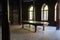 Interior of an old office with a fireplace, gothic windows and a wooden table in Sharovsky castle