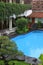Interior patio garden, on the side of the swimming pool, lush vegetation and rocks in Yogyakarta, Java, Indonesia