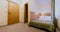 Interior of a simple and nicely furnished cozy hotel room with a double bed during daytime