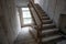 Interior of staircase of an abandoned building in the style of Soviet brutalism of the 80s, lined with limestone