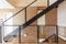 Interior staircase of a single-family house with several floors built with metal, glass railings and wooden steps