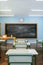 Interior of sunlit classroom with chalkboard. 3d render