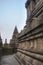 Interior of a temple in ancient Prambanan temple complex. Empty narrow corridor with reliefs on the wall.