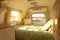 Interior of a tiny camper van with bed and small kitchen. Generative AI